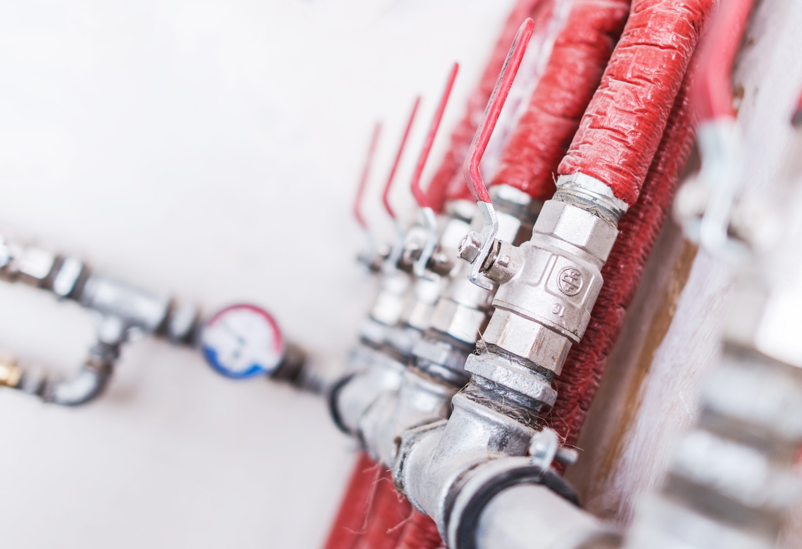 Home Plumbing System Closeup Photo. Red Isolated Pipes with Ball Valves. Residential Water Supply System.